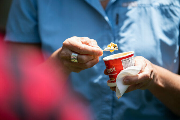 A person enjoys a scoop of orange custard chocolate chip ice cream as hundreds of people gather for an employee appreciation ice cream social on Bascom Hill at the University of Wisconsin-Madison on June 1, 2022.